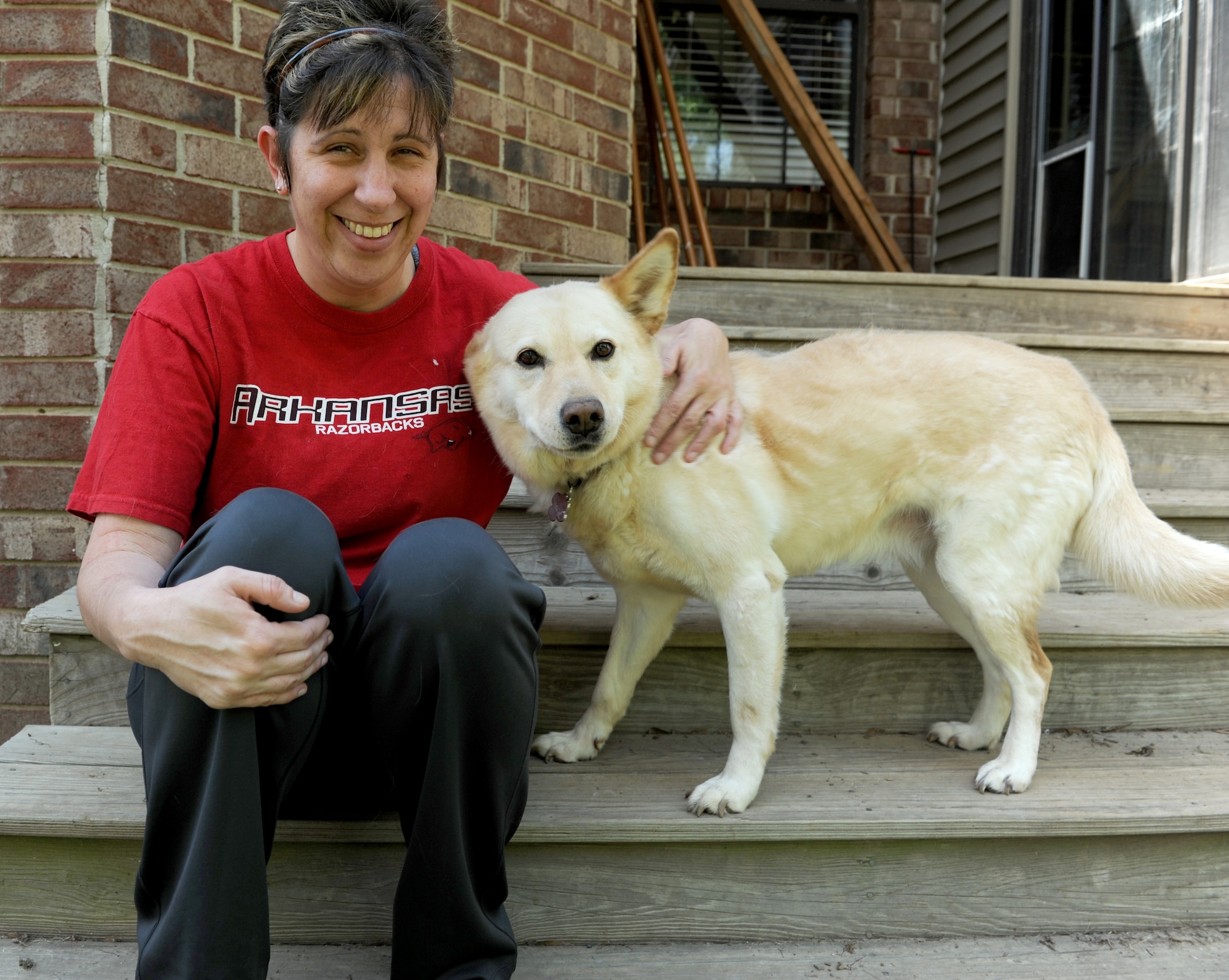 Senior Master Sgt. Melissa Spurling, 19th Force Support Squadron military personnel section superintendent, poses for a picture with her dog Rowdy, a Korean Jindo, May 7, 2013, at her house in Cabot, Ark. Spurling rescued Rowdy and his mother while stationed at Kunsan Air Base, Korea. (U.S. Air Force photo by Airman 1st Class Kaylee Clark)