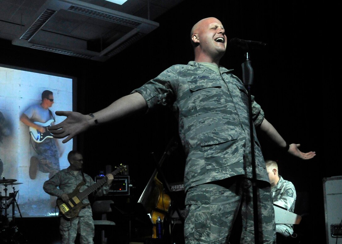 Master Sgt. Brian Carson, Max Impact vocalist, performs a medley of Max Impact’s hit songs for Air Force Association leadership during their tour of the 11th Operations Group April 10, 2013. The AFA is a non-profit aerospace education association that promotes public understanding of aerospace power and the pivotal role it plays in the security of the nation. (U.S. Air Force photo/Senior Airman Lindsey A. Porter)