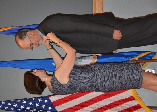 Patricia Young pins the 2012 Presidential Distinguished Rank Award gold lapel pin on Air Force Civil Engineer Center Director Joe Sciabica during a ceremony at Joint Base San Antonio-Lackland, Texas, June 5. Sciabica earned the award for his many accomplishments as the executive director of the Air Force Research Laboratory at Wright-Patterson Air Force Base, Ohio, which include leading technological advances in areas of intelligence, surveillance, reconnaissance; securing key international partnerships in critical research areas; and pioneering educational outreach programs supporting national scientific, technology, engineering, and mathematics goals. Young is the Air Force assistant deputy chief of staff for logistics, installations, and mission support. (U.S. Air Force photo/Jason Goode)