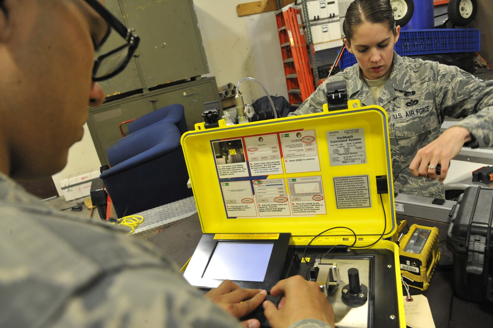 Staff Sgt. Rebecca Buhrman, 509th Civil Engineer Squadron NCO in charge of emergency management logistics, and Airman 1st Class Alfredo Guzman, 509th CES journeyman, set up the hazardous material identifier (HAZMAT ID) at Whiteman Air Force Base, Mo., May 22, 2013. Airmen use the HAZMAT ID to detect chemicals and biological agents, and provides readouts of tested material, showing whether contamination is present or not. (U.S. Air Force photo by Airman 1st Class Keenan Berry/Released)