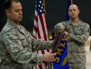 MINOT AIR FORCE BASE, N.D. -- Col. Eric Froehlich, 5th Maintenance Group commander prepares the 5th Maintenance Operations Squadron guidon to be sleeved during the 5th MOS inactivation ceremony, May 31. The squadron was comprised of three flights which included the Programs and Resource Flight, Maintenance Training Flight, and the Maintenance Operations Flight. The squadron was in charge of the administrative oversight of more than 120 Airmen. (U.S. Air Force photos/Senior Airman Brittany Y. Auld)
