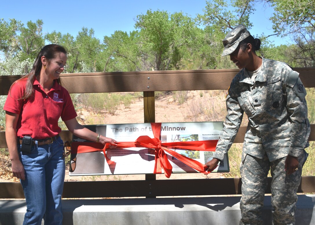 ALBUQUERQUE, N.M., -- Albuquerque District Commander Lt. Col. Antoinette Gant (left) and Ondrea Hummel, ecologist with the District, officially unwrap one of nine interpretive displays at the Rio Grande Nature Center Habitat Restoration Project Interpretive Display Ribbon Cutting ceremony, May 21, 2013.  The displays inform visitors about the restoration project, endangered species and the riparian habitat in general.