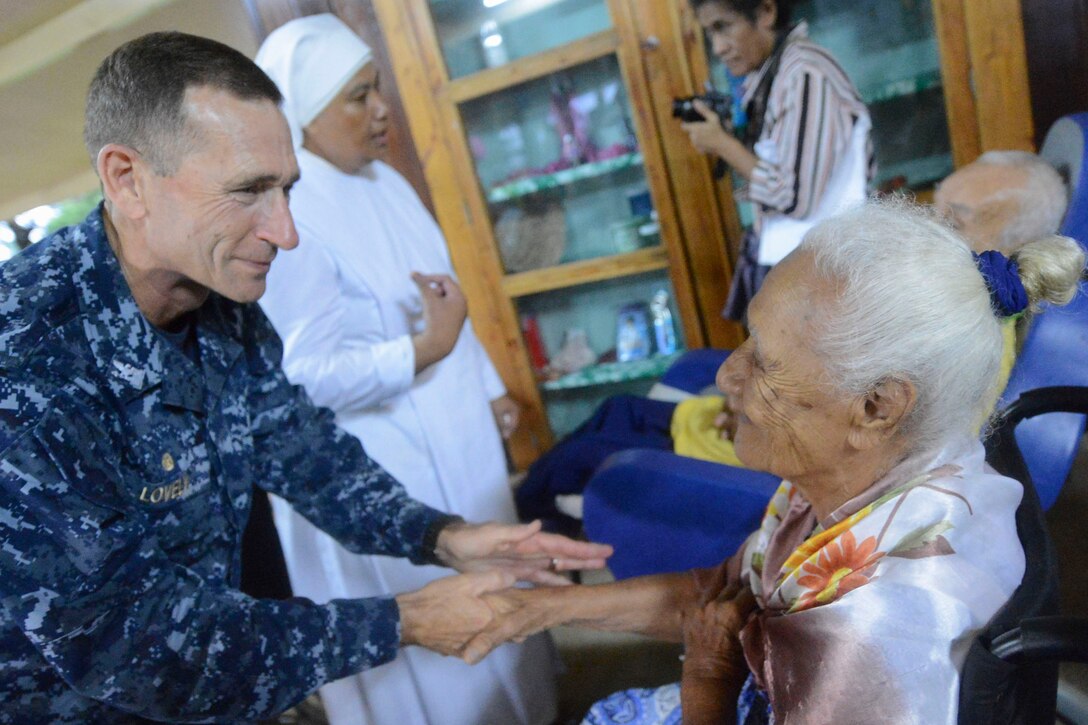 U.S. Navy Capt. Wallace Lovely speaks with a resident of Little Sisters