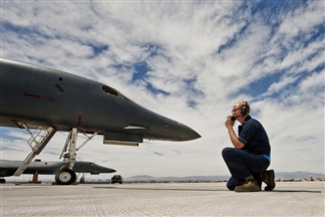 Senior Airman Matthew Crow talks via radio with the pilots in a B-1 Lancer bomber before launching for a Green Flag exercise at Nellis Air Force Base, Nev., on May 21, 2013.  Green Flag-West is an air-land integration combat training exercise involving the U.S. Air Force and conducted in conjunction with U.S. Army Combat Training Center exercises at Fort Irwin, Calif.   Crow is a crew chief assigned to the 7th Aircraft Maintenance Squadron.  