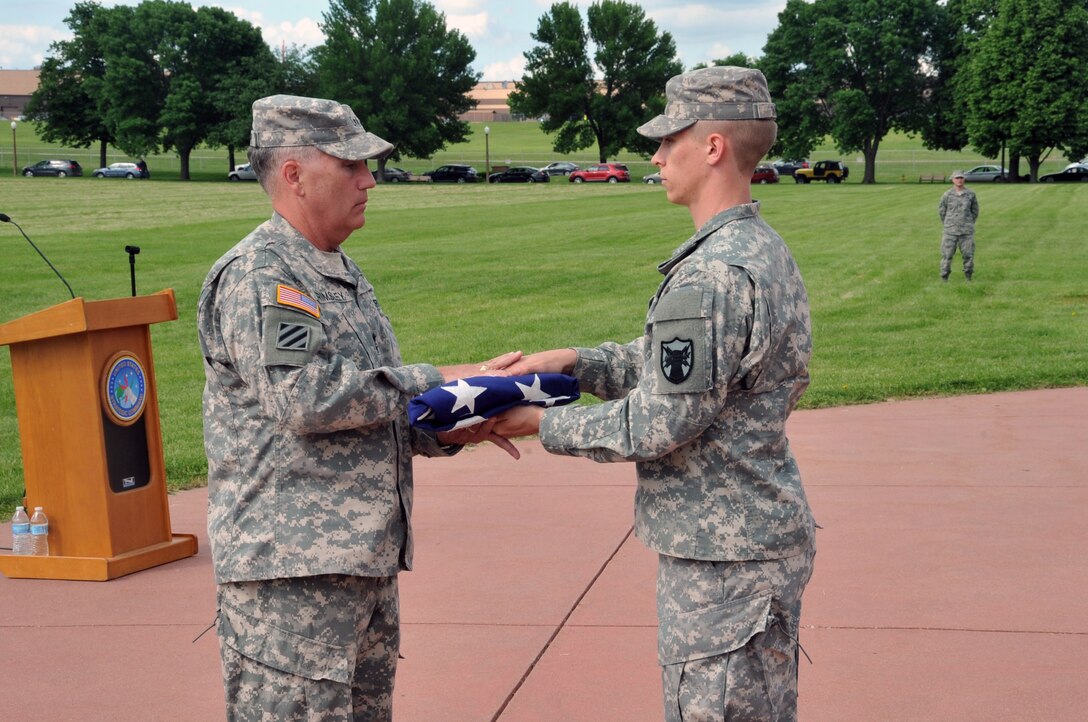 OFFUTT AIR FORCE BASE, Neb. - Army Maj. Gen. William Grimsley, Chief of Staff, U.S. Strategic Command, is presented with the U.S. flag by Spc. David Smith, U.S. Strategic Command Joint Color Guard,  during his retirement ceremony June 6, 2013 on the Offutt parade grounds.  General Grimsley is retiring after 33 years of active duty military service.   (Photo by Steve Cunningham)