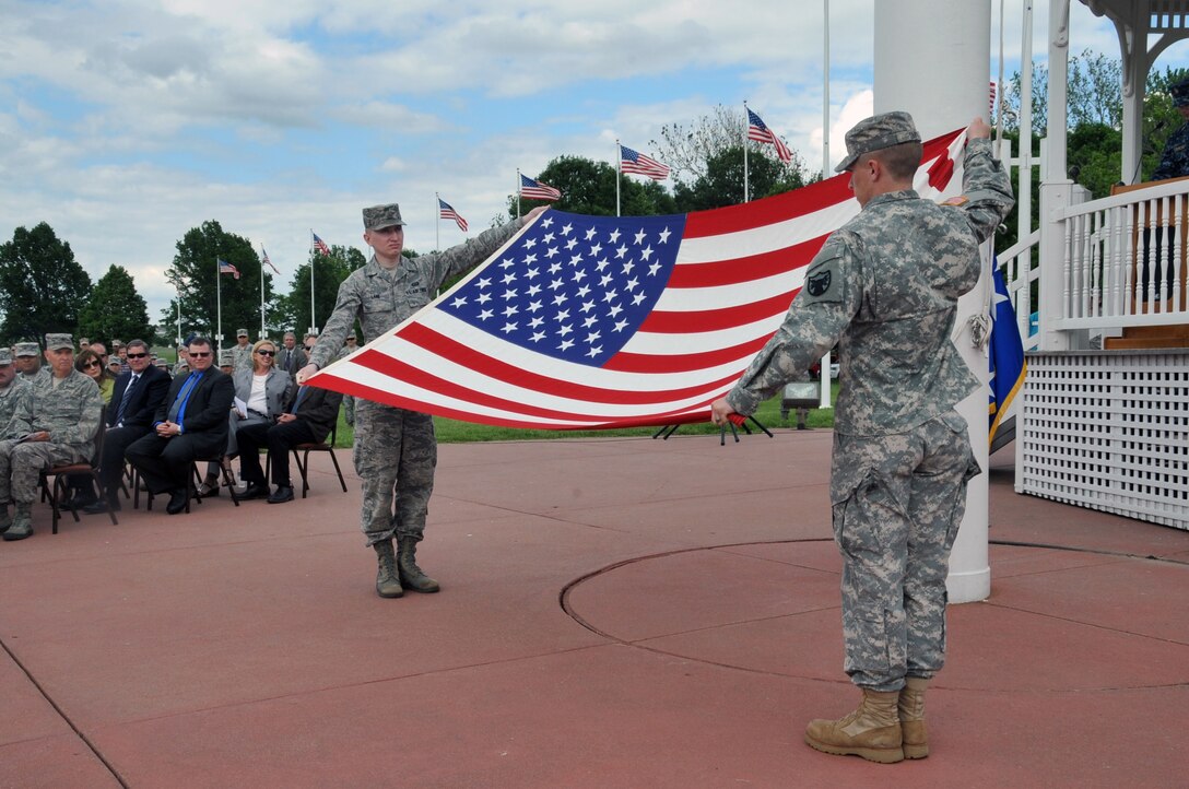 OFFUTT AIR FORCE BASE, Neb. - Airman 1st Class Dylan Lane and Spc. David Smith, U.S. Strategic Command Joint Color Guard, align and straighten out the flag in preparation for the flag folding ceremony and presentation during Maj. Gen. William Grimsley's retirement ceremony June 6, 2013 at the Offutt parade grounds.  General Grimsley, outgoing Chief of Staff, USSTRATCOM, is retiring after 33 years of active duty military service.  (Photo by Steve Cunningham)