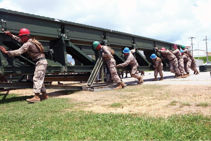 Combat engineers push a medium-girder bridge over a streambed May 30 at Camp Hansen. The MGB is a lightweight, man-portable bridge that allows troop movement and can be assembled without heavy equipment. The combat engineers
are with 9th Engineer Support Battalion, 3rd Marine Logistics Group, III Marine Expeditionary Force.