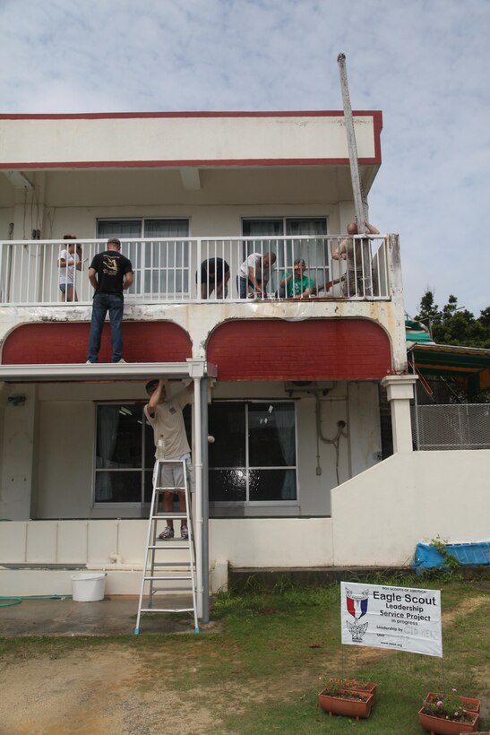 Marines clean the front of the building outside of Sugi Noko Preschool June 1 in Kin Town asa poster identifies Gid A. Merz’s Eagle Scout service project . The project is a Boy Scout’s opportunity to test his leadership abilities and give back to the community before earning the rank of Eagle Scout. Merz is a 14-year-old Life Scout with Boy Scout Troop 102, based out of Kadena Air Base. The Marines are with various units on Camp Hansen. (U.S. Marine Corps photo by Lance Cpl. Natalie M. Rostran/Released)