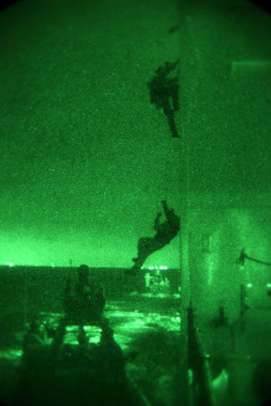 Members of 1st Marine Special Operations Battalion practice boarding and takedown of a ship at night. Marines train for Visit, Board, Search and Seizure (VBSS) at the highest level. This type of interdiction involves a non-compliant ship, underway, opposed, and at night. The operators have to attach a grappling ladder to the superstructure to board vessels with high entry points. 