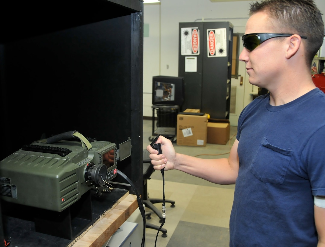 NAWCWD electronics technician Isaac Graham operates a portable laser designator during a test at the Laser Instrumentation and Designation test facility at China Lake. Graham is a Marine Reservist who works for Weapons Division when not fulfilling his Marine responsibilities. Graham has the unique opportunity to develop equipment as a civil servant that impacts his mission while serving as a Marine in combat. "The lasers and laser guided weapons systems I test and evaluate today could be the very thing that saves my life one day," Graham said.