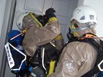 Staff Sgt. Salvatore Cautela and Sgt. Michael Gerardi check for hazardous materials as they move through a building during lane two of a Joint Collective Training Exercise between the 2nd Civil Support Team, NYARNG (CST) and the 15th CST, VTARNG. The two-day exercise held in St. Johnsbury, Vermont brought together the two teams as well as two augmentees from Rhode Island and members of the St. Johnsbury Fire Department.