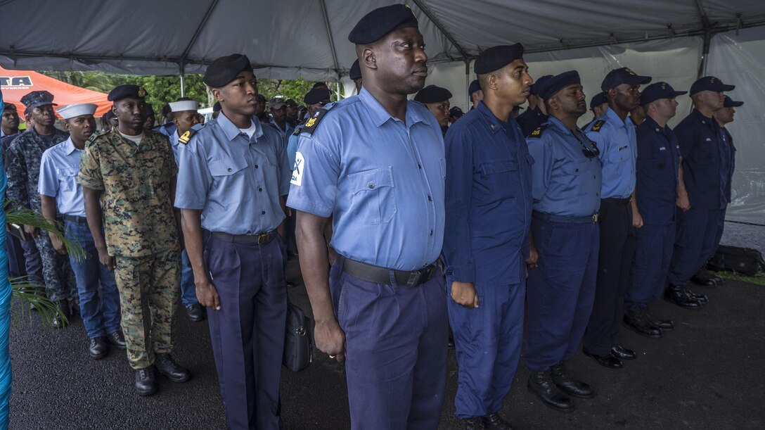 Representatives from the nations participating in Tradewinds 2013 come to the position of attention as the official party arrives to the opening ceremony. Tradewinds 2013 is a joint, combined exercise conducted in conjunction with partner nations to enhance the collective abilities of defense forces and constabularies to counter transnational organized crime and to conduct humanitarian/disaster relief operations. (U.S. Navy photo by Mass Communication Specialist 1st Class Paul Seeber/Released)