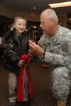 Stout Field Elementary student, Charlie Trejo, is presented a coin by Indiana Adjutant General, Maj. Gen. R. Martin Umbarger there Thursday, November 06, 2008. The adjutant general brought coats, hats and gloves for the Warm Hands, Warm Hearts program that provides students at the school with winter supplies who might not have them already.