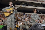 Capt. Lisa Kopczynski, public affairs officer with the 76th Infantry Brigade Combat Team, performs with the 38th Infantry Division rock band Rapid Fire during a departure ceremony in the RCA Dome in Indianapolis, Ind., on Jan. 2, 2008, before her deployment to Joint Base Balad, Iraq. Kopczynski represented the National Guard at the Operation Rising Star semifinals at Fort Belvoir, Va., on Nov. 13, 2008.