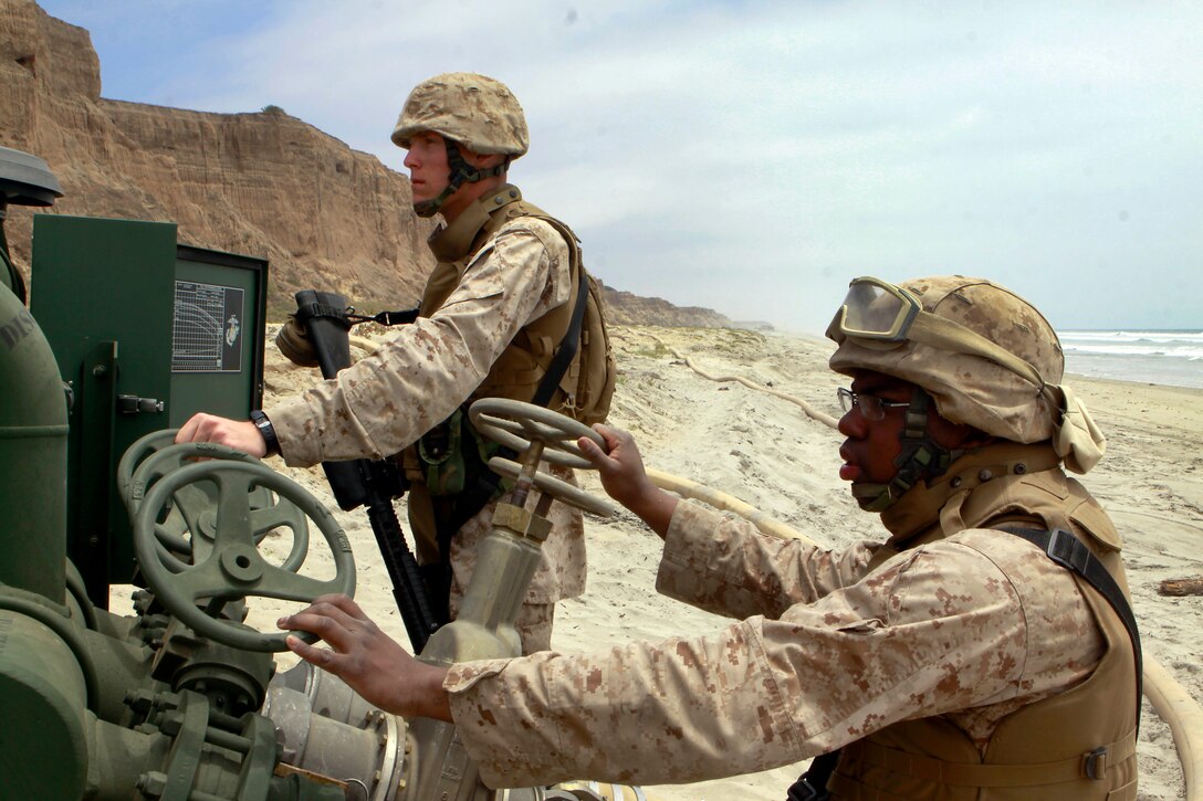 Lance Cpl. Garrett Nickum and Lance Cpl. Daniel Reid are preparing to shut a system off that is pumping water from their fuel farm to another fuel farm, manned by soldiers, one kilometer down the beach during the Quartermaster Liquid Logistics Exercise held here June 6. The Quartermaster Liquid Logistics Exercise is an Army reserve exercise that helps train service members in the movement of large amount of fuels from one fuel farm to another. Nickum is a bulk fuel specialist with Bulk Fuel Company A, stationed in Tucson, Ariz. Reid is a bulk fuel specialist with Bulk Fuel Company A, stationed in Tucson, Ariz.