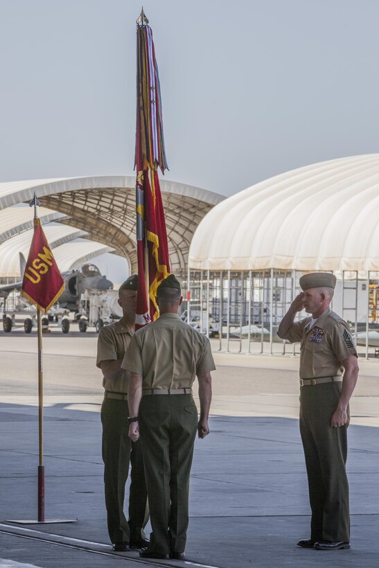 Lt. Col. Troy Pehrson, the outgoing commander of Marine Attack Squadron 211, center, passes the Marine Corps Colors to Lt. Col. Cory Simmons, the incoming commander of VMA-211, left, as Sgt. Maj. Michael Cayer, the sergeant major of VMA-211, right, salutes this symbolic act of the changing of command at the squadron hangar on Marine Corps Air Station Yuma, Ariz., May 31. Lt. Col. Pehrson’s next command will be at MCAS Cherry Point, N.C.