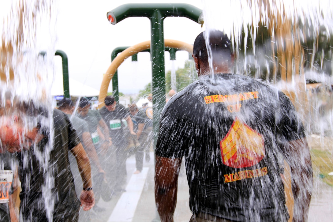 Marines enter a showering area of the 20th annual World Famous Mud Run here June 7. More than 600 Marines and sailors participated in teams of five or individually and trudged through 6.2 miles of dirt, mud and off-road obstacles.
