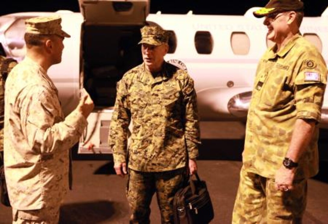 Lt. Gen. Kenneth Glueck, Jr. (center), commanding general, III Marine Expeditionary Force, speaks with Lt. Col. Matthew Puglisi (left), officer-in-charge, Marine Rotational Force – Darwin, and Air Commodore Ken Watson (right), commander, Northern Command, Royal Australian Air Force, after landing here, May 27. Glueck flew to Australia to visit MRF-D Marines and tour surrounding military facilities.

