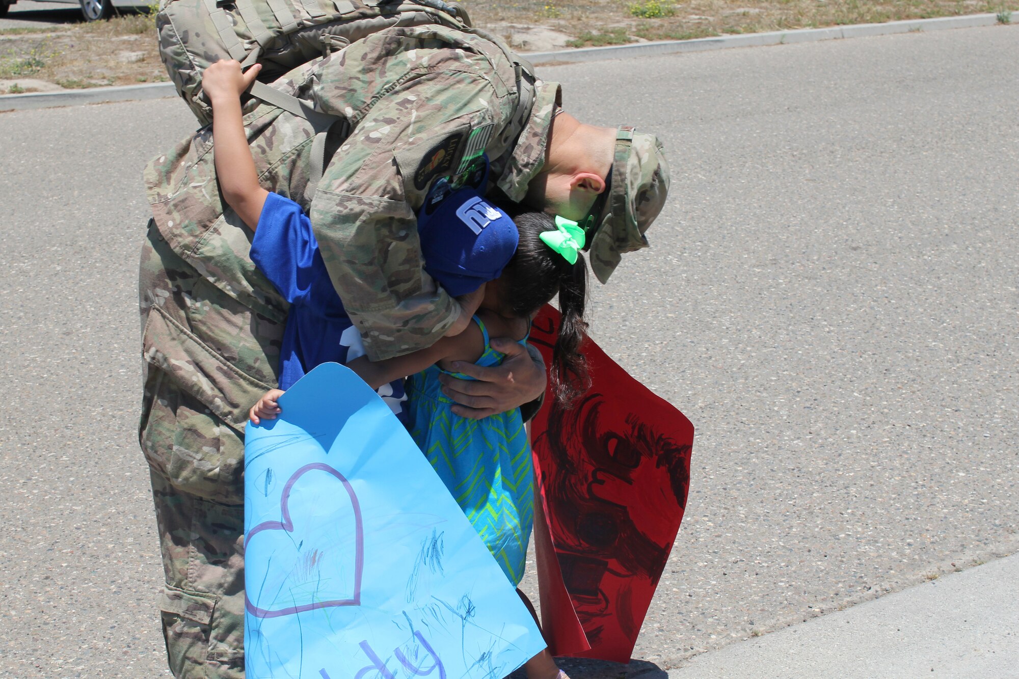 VANDENBERG AIR FORCE BASE, Calif.—Tech. Sgt. Eric Bergery, 30th Security Forces Squadron patrolman, hugs his son and daughter immediately after stepping off of a bus outside the 30th Security Forces Squadron building here June 7, 2013. Bergery and 10 other defenders returned from a six-month deployment in an undisclosed location in Southeast Asia. (U.S. Air Force photo/2nd Lt. Kaylee Ausbun)