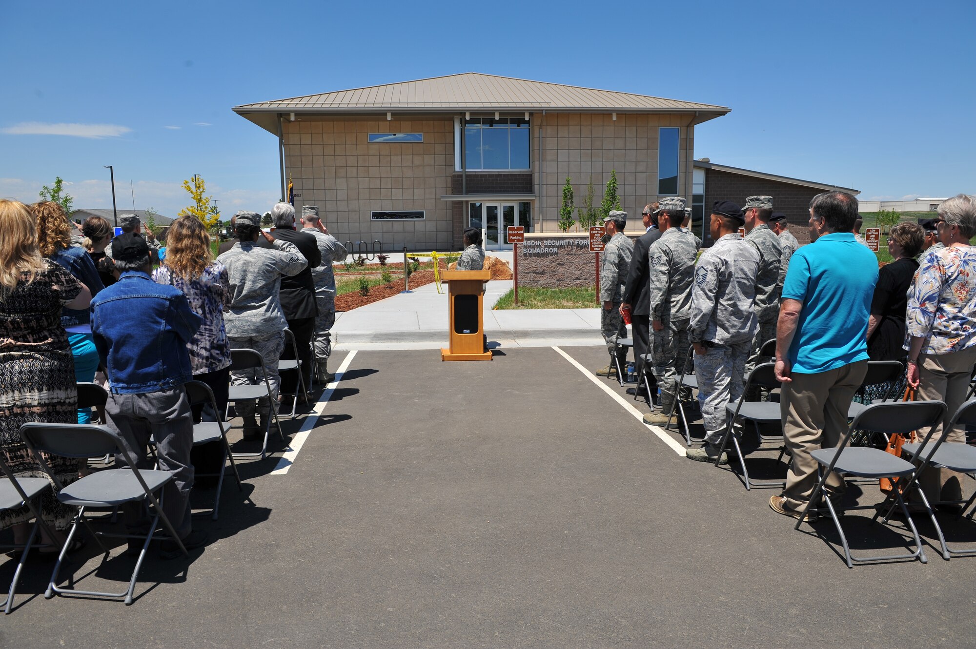 Team Buckley members salute the flag during the 460th Security Forces Squadron ribbon-cutting ceremony June 6, 2013, on Buckley Air Force Base . The new 35,000 square-foot facility is designed to be environmentally conscious and consolidate all parts of security forces into one building. (U.S. Air Force photo by Senior Airman Phillip Houk/Released)