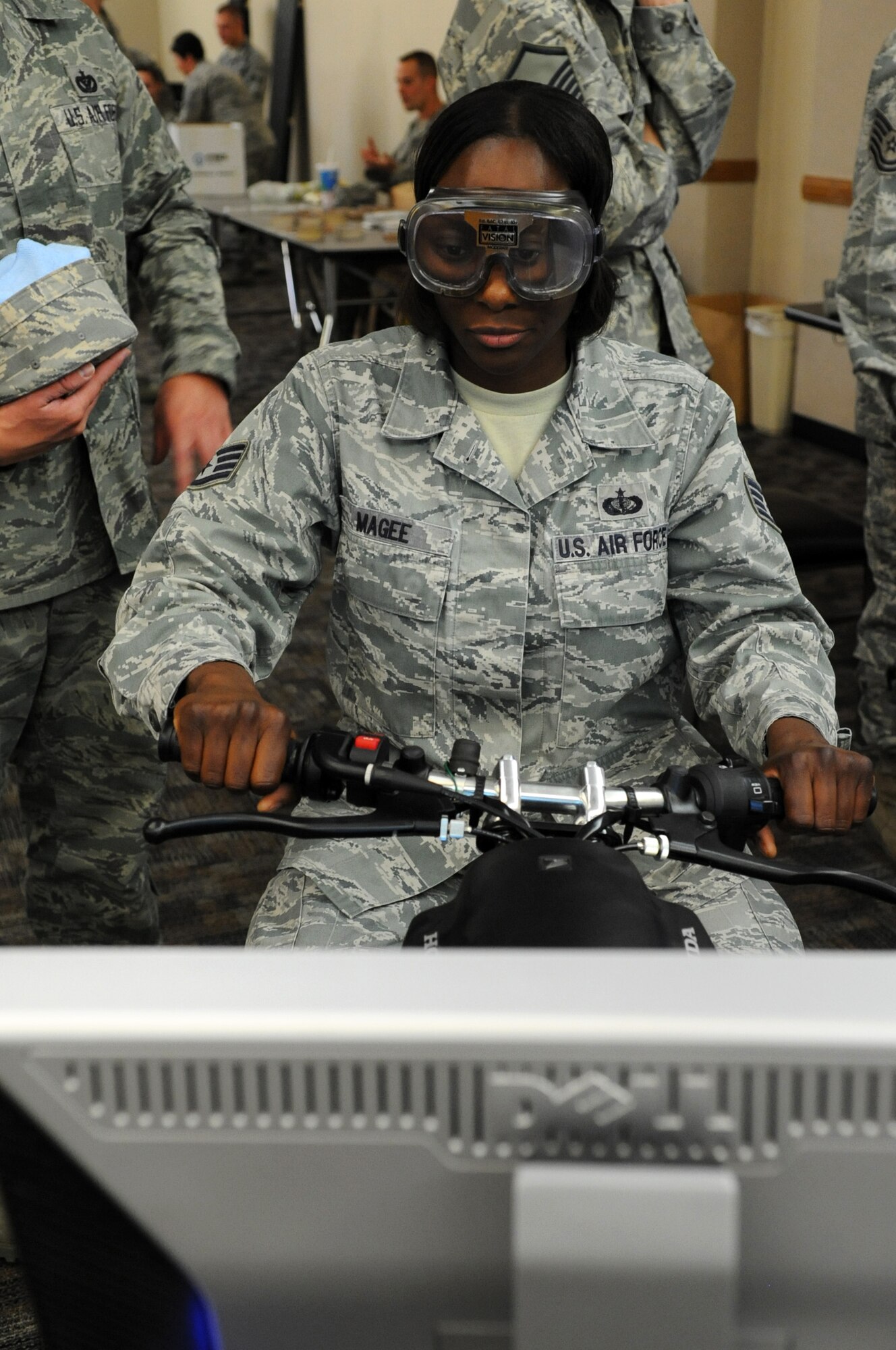 Staff Sgt. Marquita Magee, 56th Force Support Squadron flight kitchen supervisor, rides a motorcycle simulator while wearing “beer goggles” May 23 during a safety fair at Luke Air Force Base. The event featured interactive information booths with an emphasis on general safety awareness. (U.S. Air Force photo/Staff Sgt. Nestor Cruz)