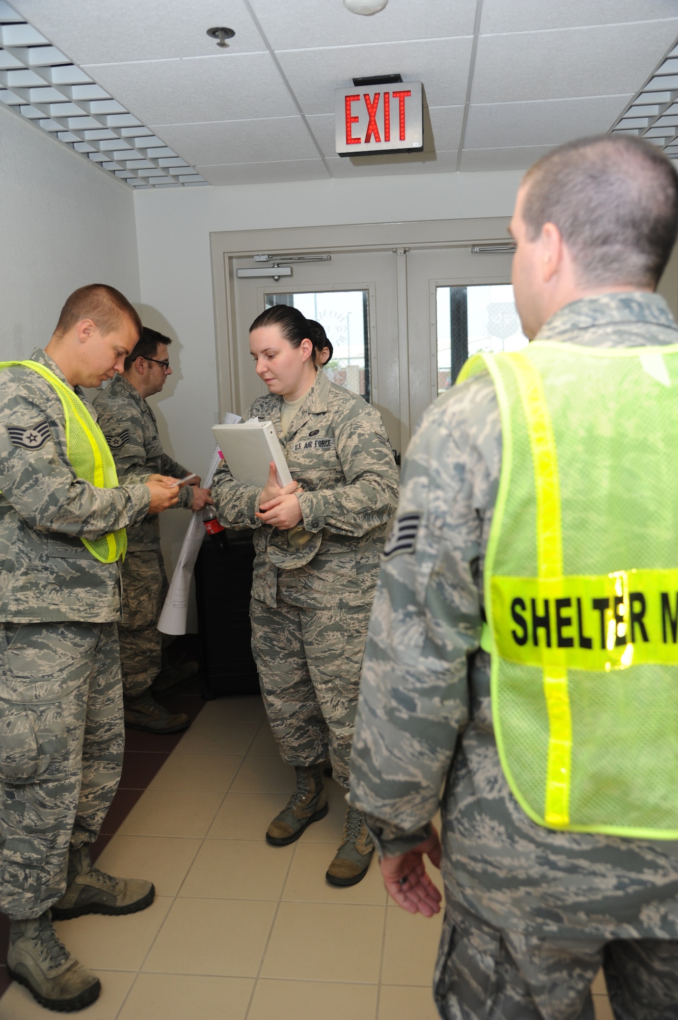 Staff Sgt. Adam Lougee, 335th Training Squadron and shelter management team member, checks the identification of Senior Airman Natasha Gagnon, 81st Force Support Squadron, during a hurricane exercise June 7, 2013, at Wolfe Hall, Keesler Air Force Base, Miss.  The purpose of the exercise was to prepare Keesler for the current hurricane season.  (U.S. Air Force photo by Kemberly Groue)