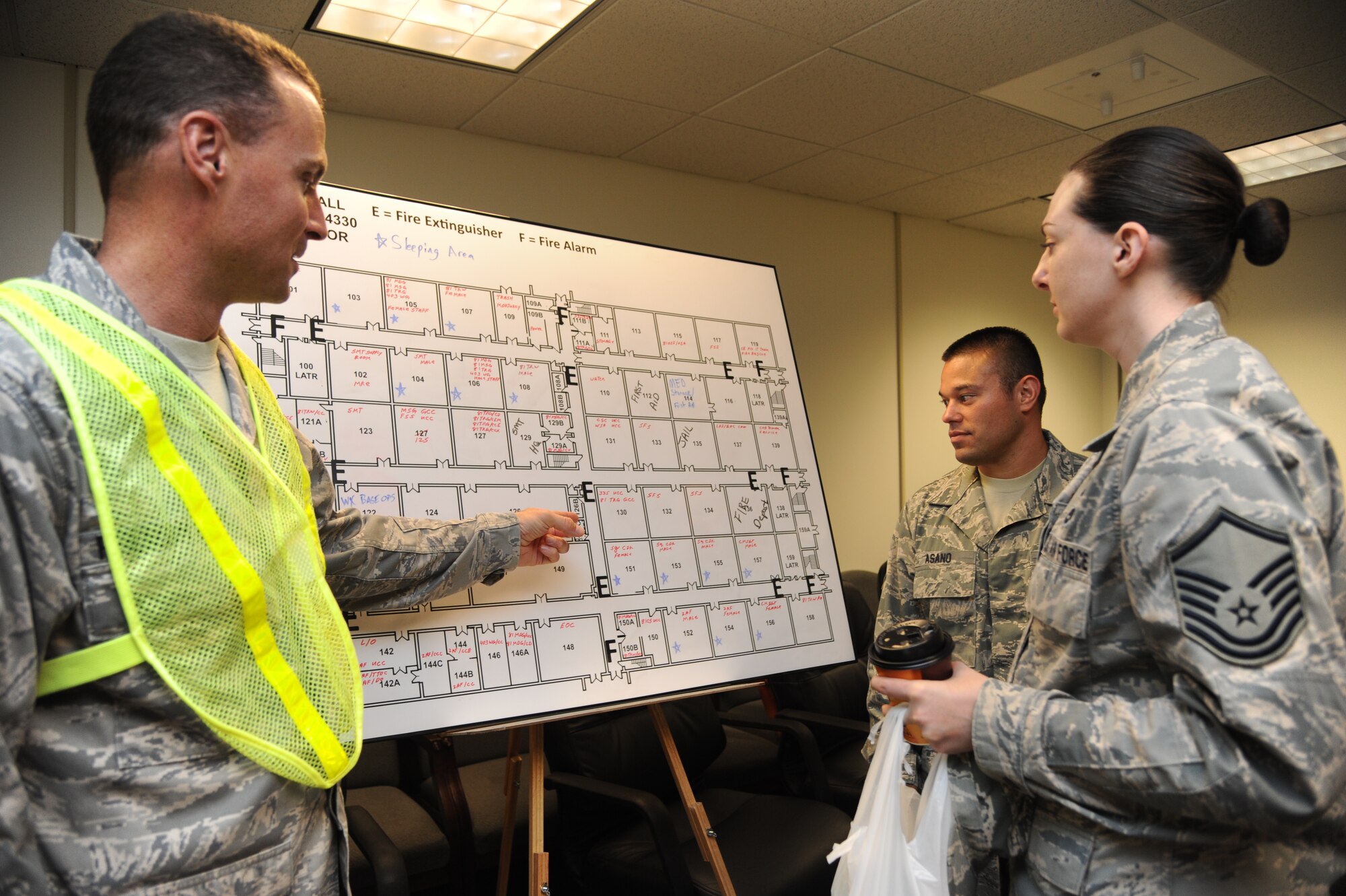 Master Sgt. David Polmanteer, 335th Training Squadron and shelter management team member, shows a building chart to Tech. Sgt. Vicente Asano and Master Sgt. Erika Stoyko, 81st Training Support Squadron, to help them find their sheltering room during a hurricane exercise June 7, 2013, at Wolfe Hall, Keesler Air Force Base, Miss.  The purpose of the exercise was to prepare Keesler for the current hurricane season.  (U.S. Air Force photo by Kemberly Groue)