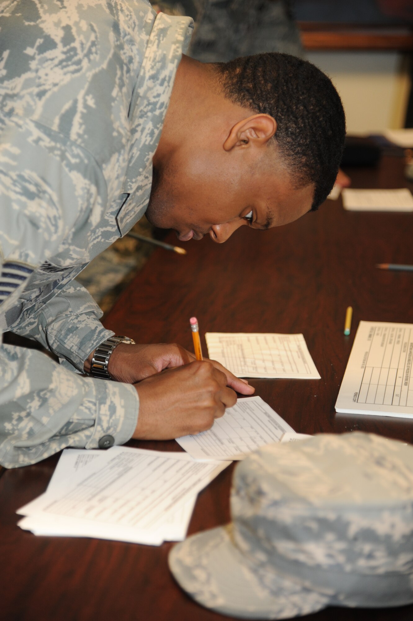 Tech. Sgt. Tyrone Edwards, 81st Operations Support Flight, completes hurricane shelter in-processing forms during a hurricane exercise June 7, 2013, at Wolfe Hall, Keesler Air Force Base, Miss.  The purpose of the exercise was to prepare Keesler for the current hurricane season.  (U.S. Air Force photo by Kemberly Groue)