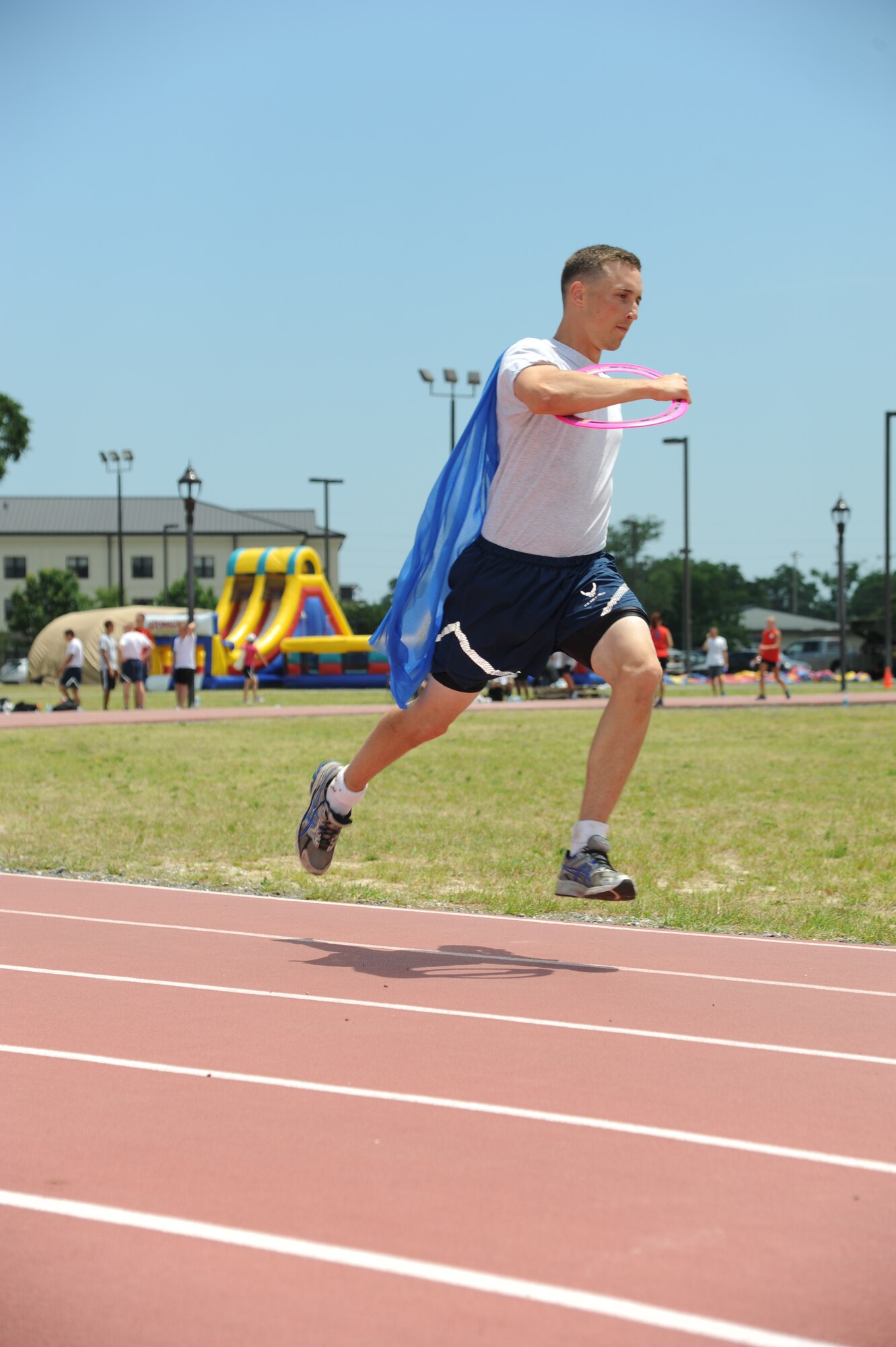 Airman Matthew Ludvik, 338th Training Squadron, sprints around the track wearing a cape and carrying a disk during the fourth Annual Dragon Challenge June 7, 2013, at the triangle track, Keesler Air Force Base, Miss.  The Dragon Challenge is an 8-12 person relay event to raise funds for the Fisher House and Wounded Warrior Project.  Nineteen teams participated in the 12-hour event.  (U.S. Air Force photo by Kemberly Groue)