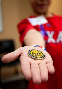 A child of a deployed Airman displays his new “Little Hero” coin that he received from his parent’s squadron commander, April 5, 2013 at McConnell Air Force Base, Kan. The Little Heroes program recognizes children and spouses for their struggles during separations caused by deployments 45 days or longer. (U.S. Air Force photo/Airman 1st Class Victor J. Caputo)
