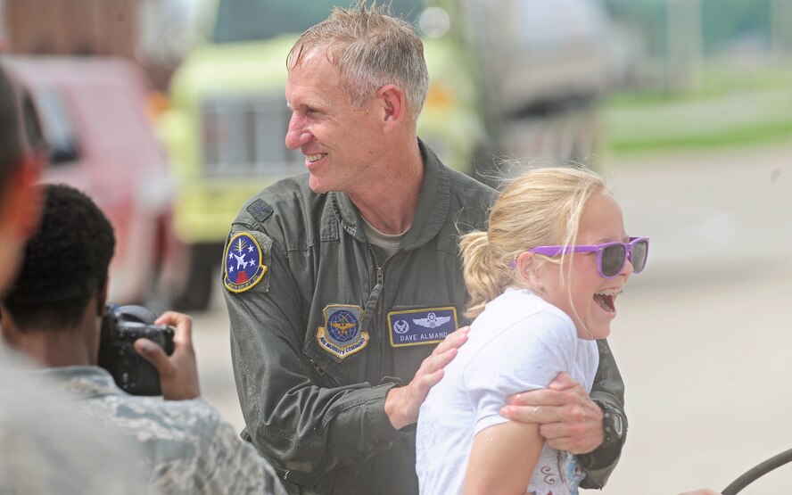 Col. David Almand, 375th Air Mobility Wing commander, chases a family friend while he is getting sprayed by his family and friends following his fini-flight as wing commander at Scott Air Force Base, Ill. June 6, 2013. A commander's fini-flight is an Air Force tradition meant to honor and thank the commander for his service. Almand will relinquish his command of the 375th at a change of command ceremony 14 June, 2013.(U.S. Air Force photo/ Staff Sgt. Ryan Crane)