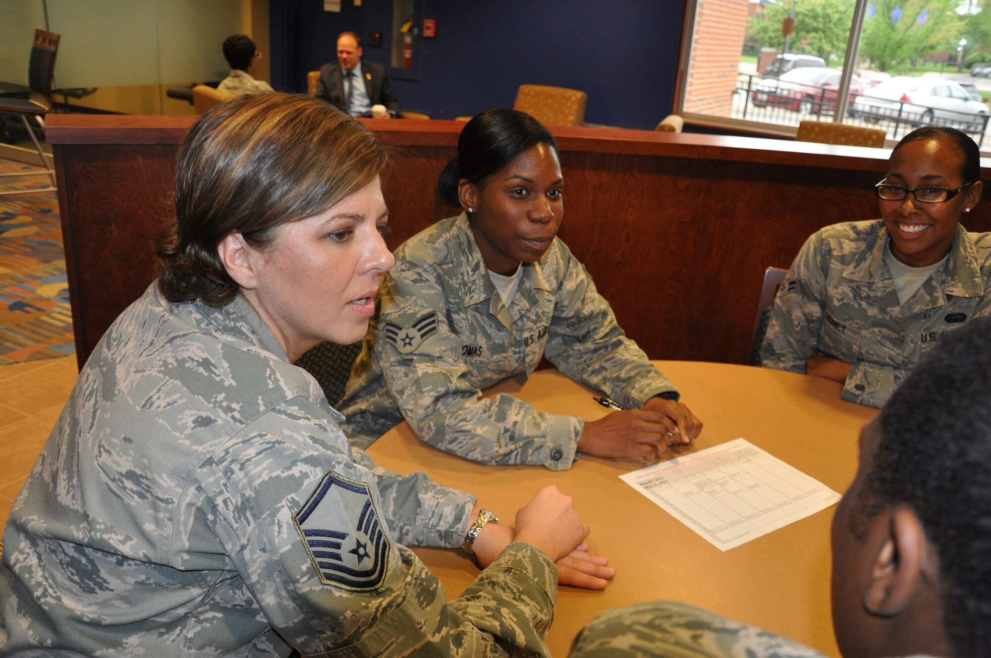 Senior Airman Natasha Thomas (center), Air Mobility Command Air Intelligence Squadron knowledge operator, and her fellow coworkers discuss plans for their booster club. Thomas' involvement in her squadron's booster club, among other activities, led to her 2012 Air Intelligence Squadron Volunteer of the Year Award. (U.S. Air Force photo/Staff Sgt. Amber R. Kelly-Herard)