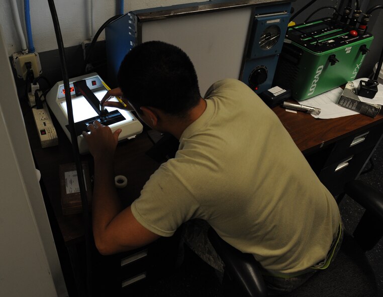 Airman 1st Class Leonard Avalos, 2nd Maintenance Squadron non-destructive inspection, checks the density of a film on Barksdale Air Force Base, La., June 7, 2013. NDI Airmen verify the film accurately recorded the piece of equipment being inspected. (U.S. Air Force photo/Airman 1st Class Benjamin Gonsier)