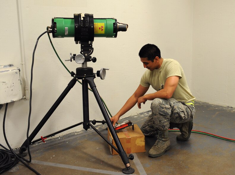 Airman 1st Class Leonard Avalos, 2nd Maintenance Squadron non-destructive inspection, places a weld under an X-radiation machine on Barksdale Air Force Base, La., June 7, 2013. A piece of film is placed under the weld and the X-ray machine will shoot radiation towards it. The weld will be printed on the film for Airmen to properly inspect the piece. (U.S. Air Force photo/Airman 1st Class Benjamin Gonsier) 