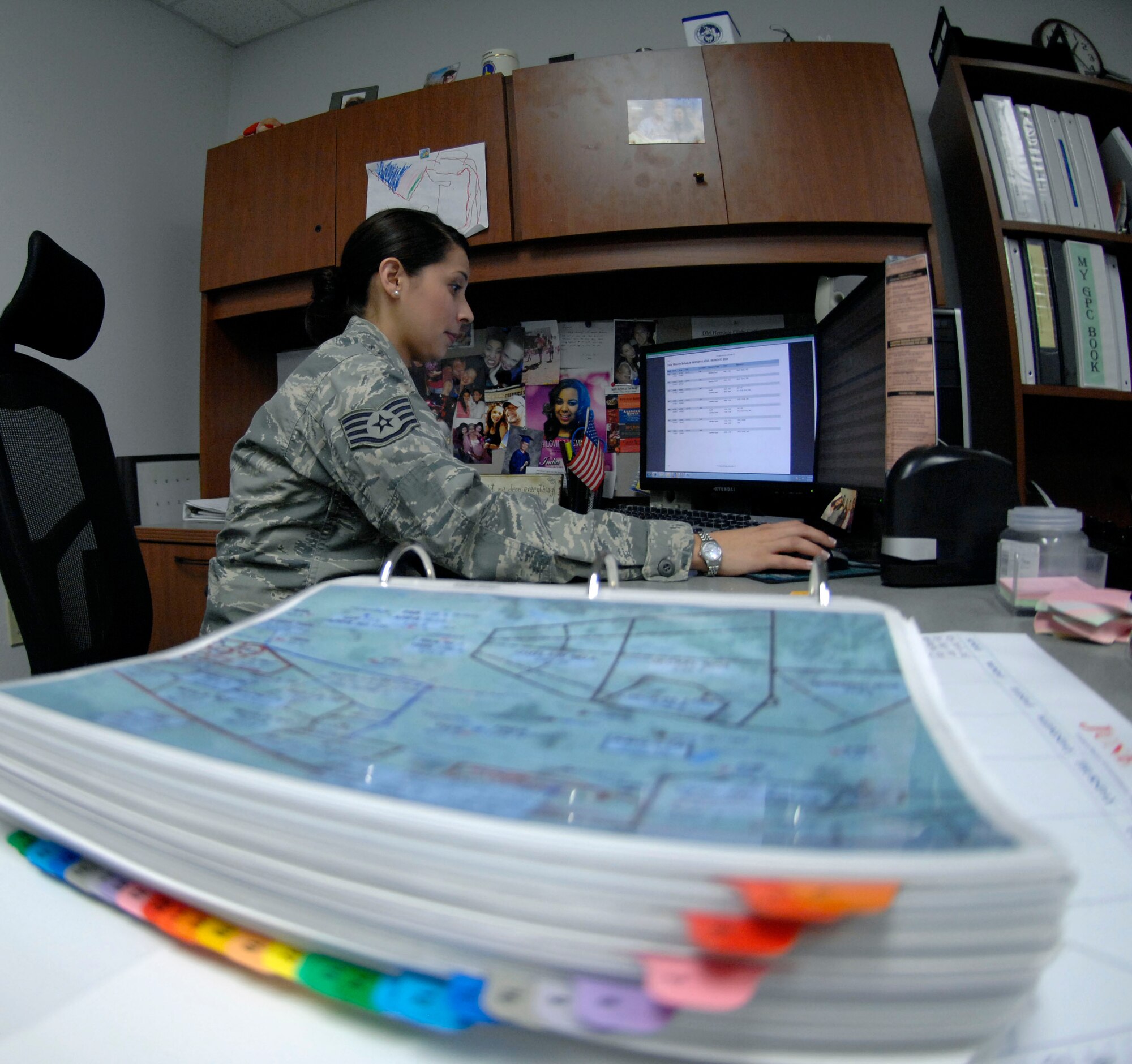 U.S. Air Force Staff Sgt. Amanda Villarreal, 355th Operations Support Squadron noncommissioned-officer-in-charge of wing scheduling, reserves air space for installation aircraft at Davis-Monthan Air Force Base, Ariz., June 4, 2013. The map sitting on her desk illustrates the airspace by sections, allowing her to quickly and easily schedule airspace over areas such as Tombstone, Ariz. (U.S. Air Force photo by Airman 1st Class Saphfire Cook/Released)