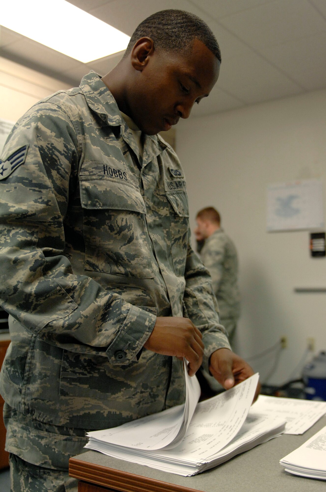 U.S. Air Force Senior Airman Tyrone Hobbs, 355th Operations Support Squadron flight records, separates paperwork to be placed in squadron members' Annual Products at Davis-Monthan Air Force Base, Ariz., June 4, 2013. An Annual Product is a collection of records, such as flying hours, that is compiled by flight records and reviewed by squadron members once a year. (U.S. Air Force photo by Airman 1st Class Saphfire Cook/Released)