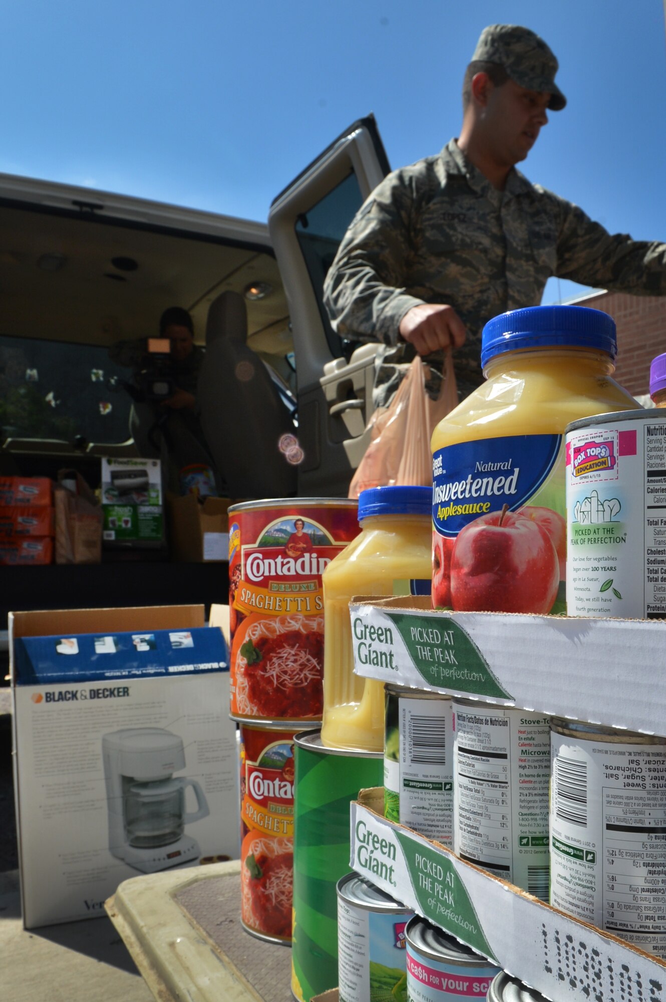Senior Airman Alex Lopez, 56th Operations Support Squadron weather forecaster, unloads a van full of supplies and food May 9 at the Marine, Army, Navy, Air Force House. The MANA House provides tools and resources to homeless veterans in need of assistance. (U.S. Air Force photo/Senior Airman Kate Vaughn)