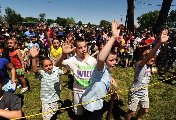 Children rush the yellow line eager to answer trivia questions in exchange for prizes during the 2013 Offutt Appreciation Day Picnic held at the Base Lake on May 31, Offutt Air Force Base, Neb. The larger raffle prizes included mountain bikes, a custom painted grill and a 55 inch Vizio television. (U.S. Air Force photo by Josh Plueger)