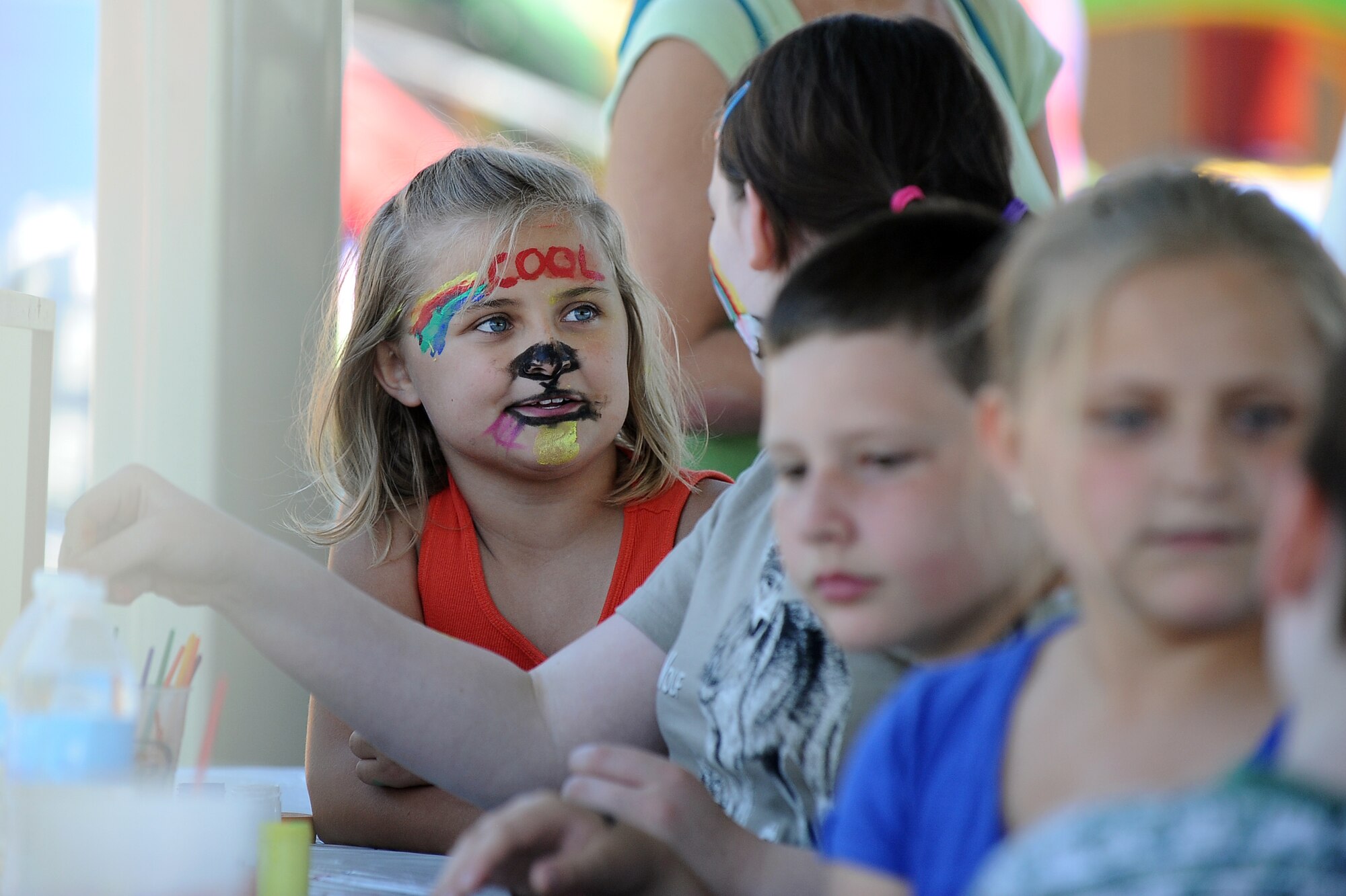 Eight-year-old Georgia Earnest, daughter of retired Air Force Edward Earnest, sits with her friends at one of the numerous face painting booths during the annual Offutt Appreciation Day Picnic held at the Base Lake on May 31, Offutt Air Force Base, Neb.  The annual picnic is put on for Team Offutt members by the Offutt Advisory Council. (U.S. Air Force photo by Josh Plueger/Released)