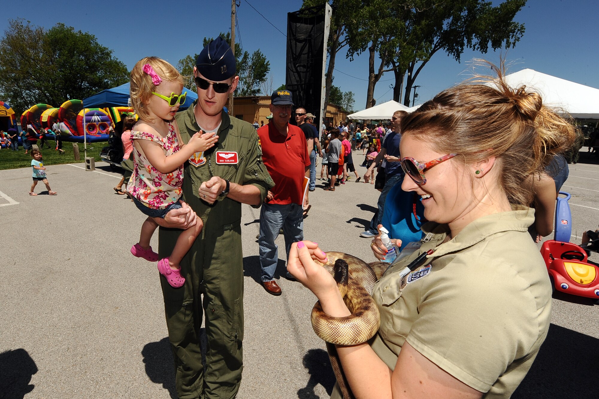 U.S. Air Force Capt. Dan Carlson, 343rd Reconnaissance Squadron, holds his two-year-old daughter Julianna as they take a closer look at a black headed python courtesy of Omaha’s Henry Doorly Zoo during the 2013 Offutt Appreciation Day Picnic held at the Base Lake, Offutt Air Force Base, Neb.  Hundreds of military families from both the 55th Wing and its tenant units came to the Base Lake to enjoy an afternoon of free entertainment and food courtesy of the Offutt Advisory Council. (U.S. Air Force photo by Josh Plueger/Released)