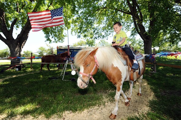 Three-year-old Taylor Barner, son of Trent Barner, a retired U.S. Navy service member, goes for a pony ride while attending the 2013 Offutt Appreciation Day Picnic held at the Base Lake on May 31, Offutt Air Force Base, Neb. Thousands of Offutt Airman, DoD employees and their dependents had an afternoon filled with free food and entertainment courtesy of the Offutt Advisory Council. (U.S. Air Force photo by Josh Plueger/Released)