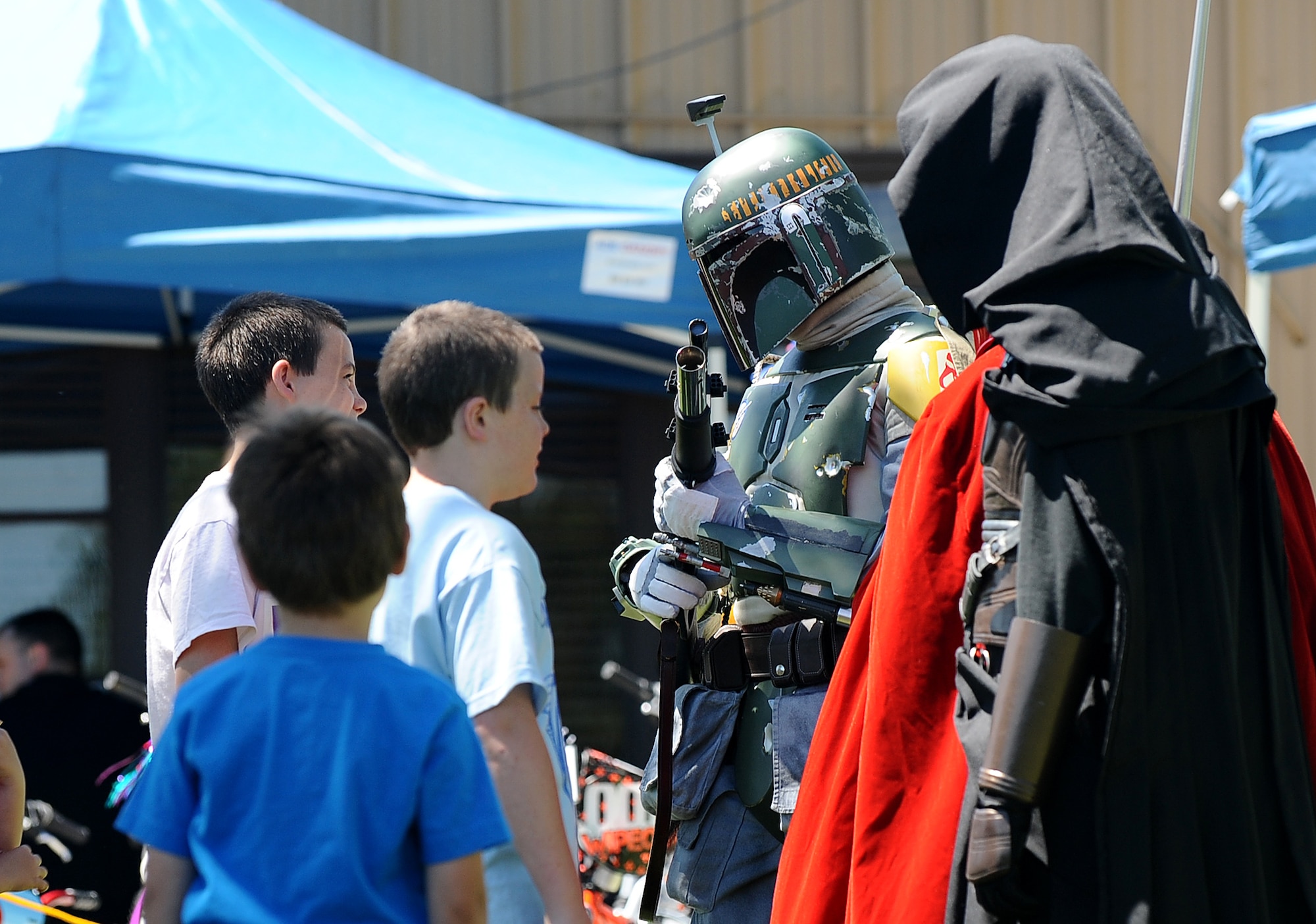 Boba Fett, a bounty hunter with the 5O1st Legion, greets children attending the 2013 Offutt Appreciation Day Picnic at the Base Lake on May 31, Offutt Air Force Base, Neb. The 5O1st is comprised of volunteers that make special guest appearances all over the country.  (U.S. Air Force photo by Josh Plueger/Released)