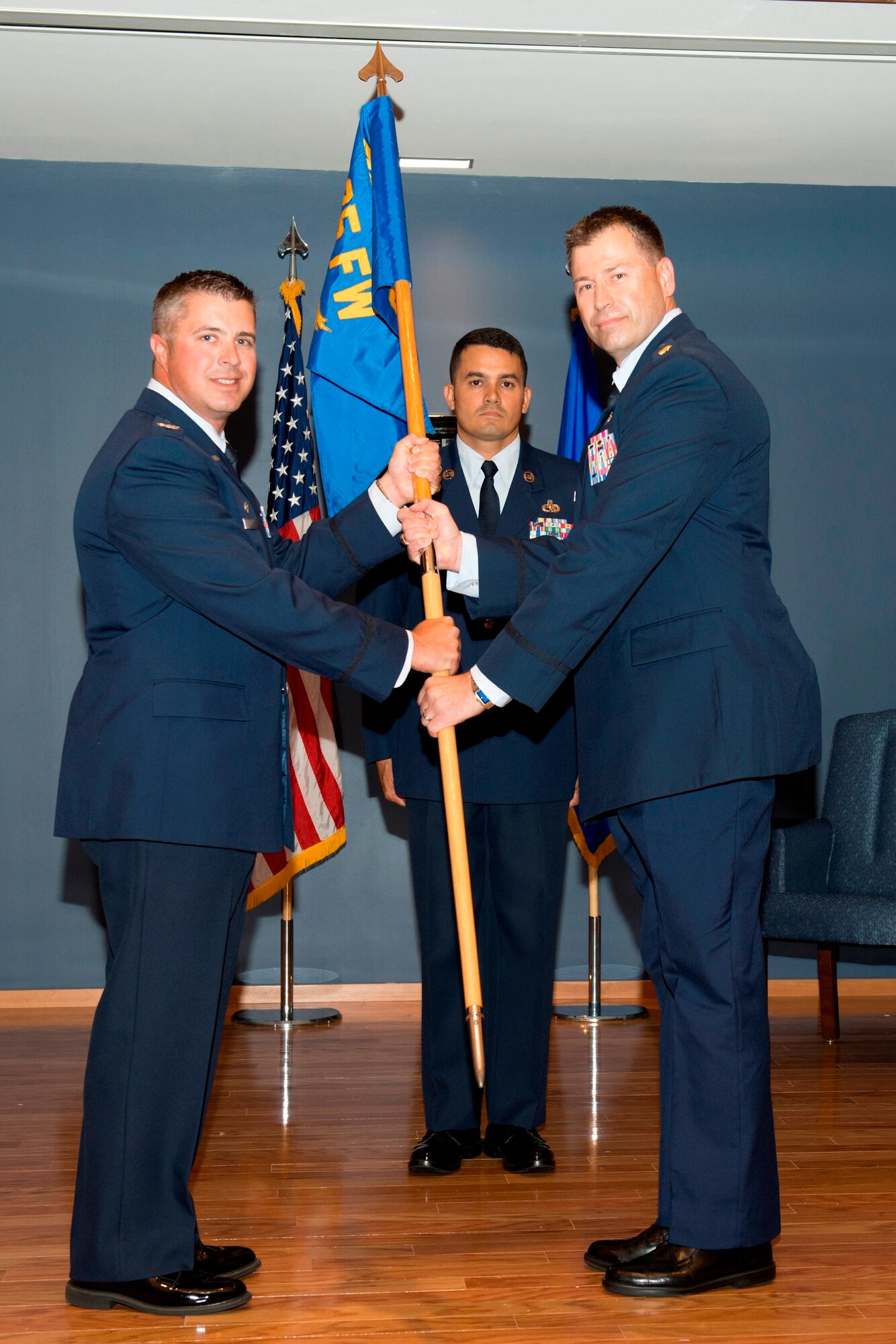 Colonel David E. Graff, 325th Fighter Wing commander, passes the 325th Comptroller Squadron guidon to Maj. Timothy Fast, 325th CPTS commander during a change of command ceremony June 7 as Senior Master Sgt. Jose Nunez, 325th Force Support Squadron, 325th CPTS, and 325th Fighter Wing Staff Agencies First Sergeant, looks on. (U.S. Air Force photo by Lisa Norman)