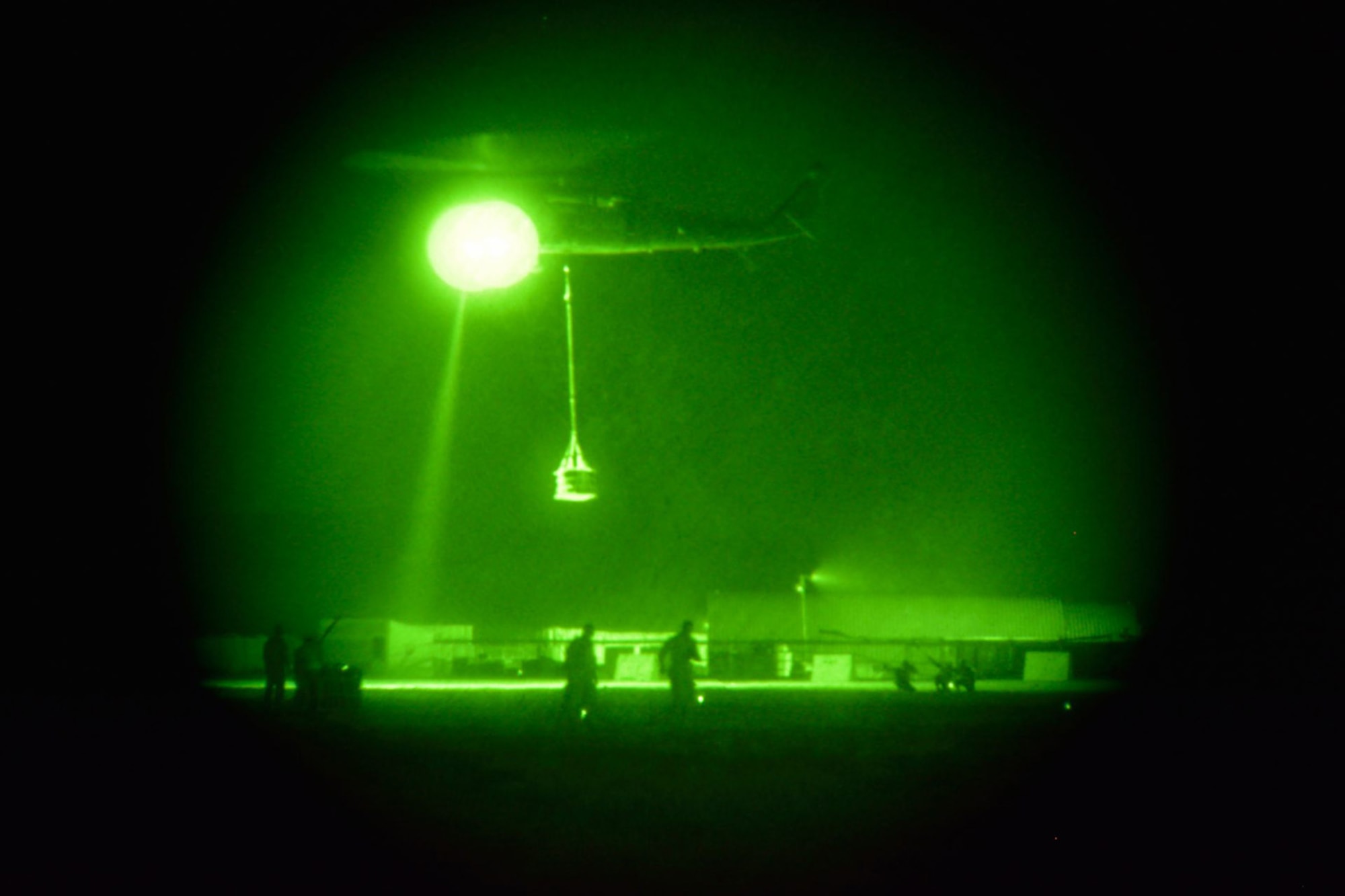 With chemical lights dotting the ground, Soldiers from A Company, 2-3 General Support Aviation Battalion, depart with an 1,800 pound A-22 cargo bag beneath their UH-60 Black Hawk helicopter.  A hook-up team from the 451st Expeditionary Logistics Readiness Squadron (far right) monitors the aircraft's egress during a coalition-joint slingload mission at Kandahar Airfield, Afghanistan.  Capt. Chris Kaighen, a Reservist  from the 86th Aerial Port Squadron, McChord Airfield, Wash., took part of this operation. (U.S. Air Force photo by Jonathan D. Assaid)