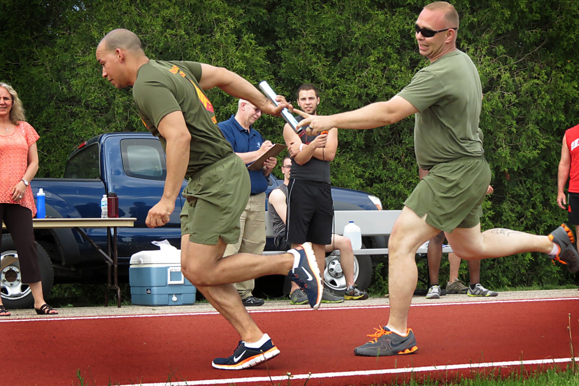 GRISSOM AIR RESERVE BASE, In. -- Joe Jusino, a Marine from Det. 1 Communications Company, Headquarters and Service Battalion, 4th Marine Logistics Group, takes the baton from a fellow Marine as and begins his portion of a 2400-meter relay May 16. The Grissom Fitness Center held various competitive events throughout the month as part of the Air Force's recognition of May as Fitness Month. (U.S. Air Force photo/Becca Hammer)