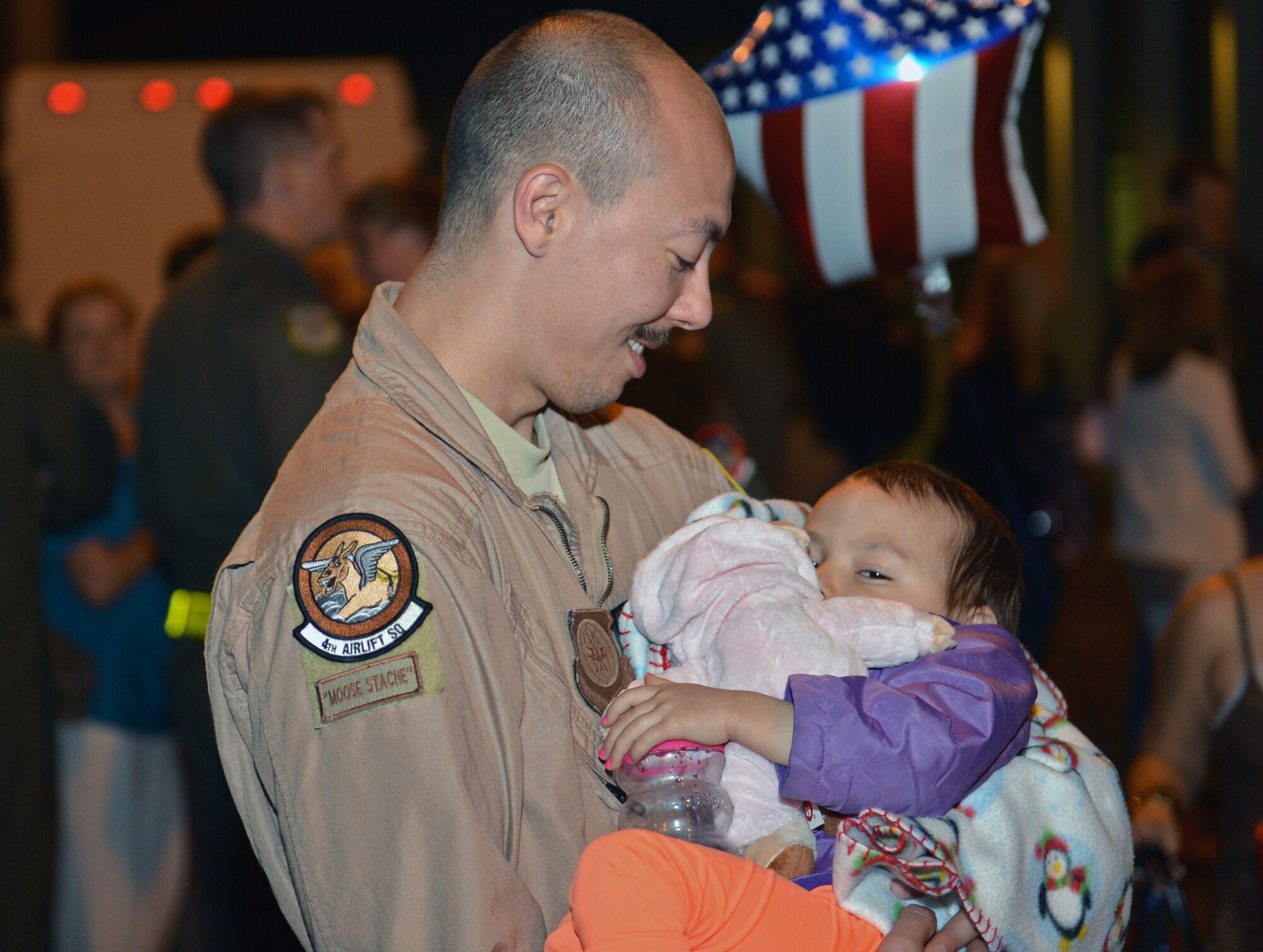 Staff Sgt. Jason Livingston, 4th Airlift Squadron loadmaster, holds his daughter after returning from a deployment June 6, 2013, at Joint Base Lewis-McChord, Wash. The 4th AS deployed to Southwest Asia and were accompanied by Airmen from Elmendorf Air Force Base, Alaska and Joint Base Pearl Harbor-Hickam, Hawaii. (U.S. Air Force photo/Staff Sgt. Jason Truskowski)