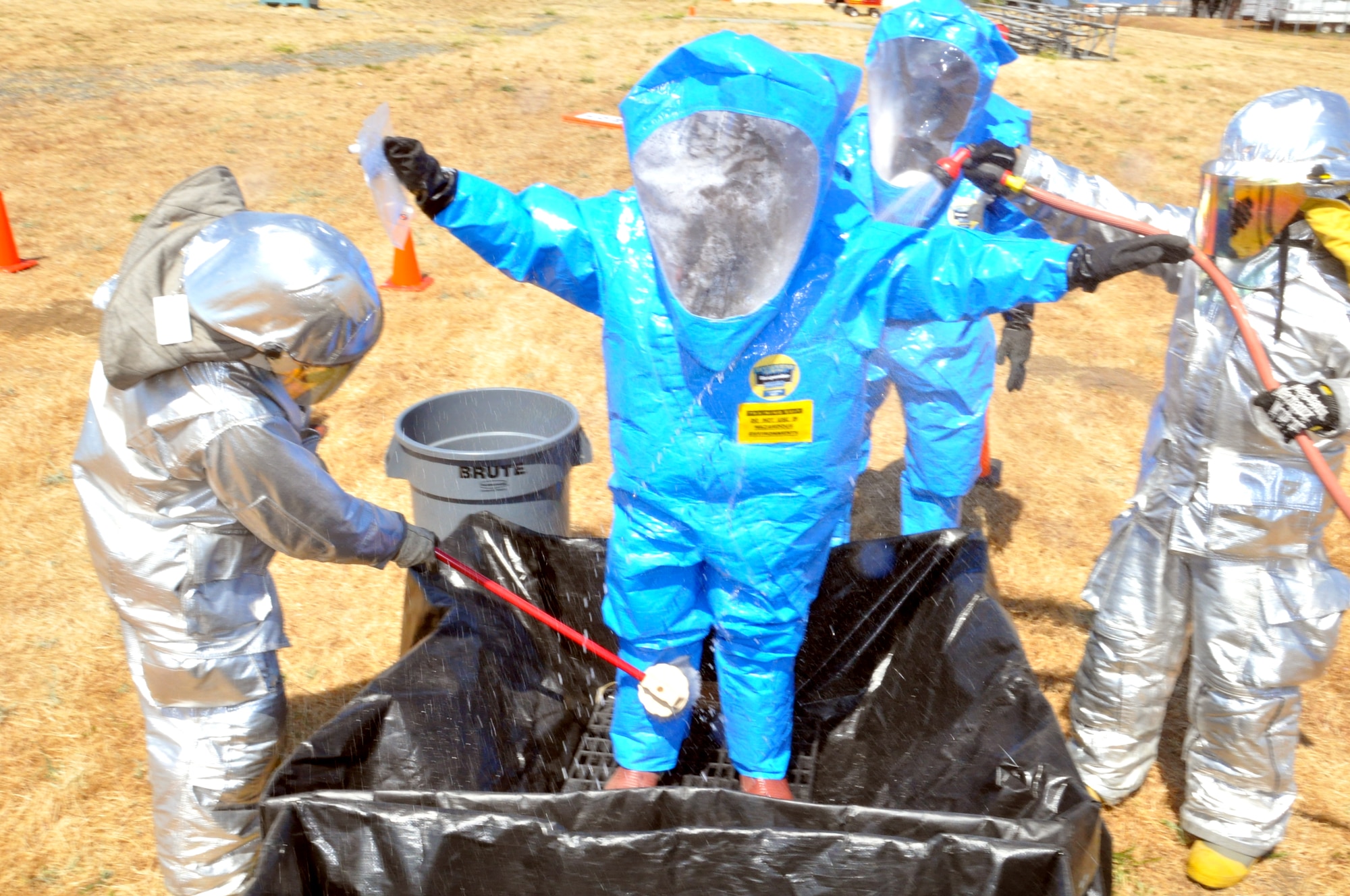 Airmen from the 60th CES fire protection flight decontaminate and Airman from the 60th AMDS bioenviromental flight June 6 during an exercise on Travis. (U.S. Air Force photo/Staff Sgt. Patrick Harrower)