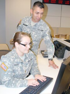 First Lt. Eric Guerrero (right), 14th Military Intelligence Battalion S1 (personnel officer), reviews procedures with 2nd Lt. Samantha Squires, 338th MI Battalion S1. The 14th MI Battalion, which deployed to Afghanistan for a year ending last October, has been helping its sister unit get ready for deployment. (Photo by Gregory Ripps)