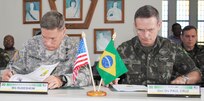 Maj. Gen. Frederick S. Rudesheim, the commanding general of U.S. Army South, and Brazilian Lt. Gen. Luiz Guilherme Paul Cruz, deputy chief for Special and International Affairs of the Brazilian army, sign a memorandum of understanding during the closing ceremony of the army-to-army staff talks between the U.S. and Brazilian armies May 22 in Manaus, Brazil. (Photo by Lt. Col. Robert A. Whetstone)