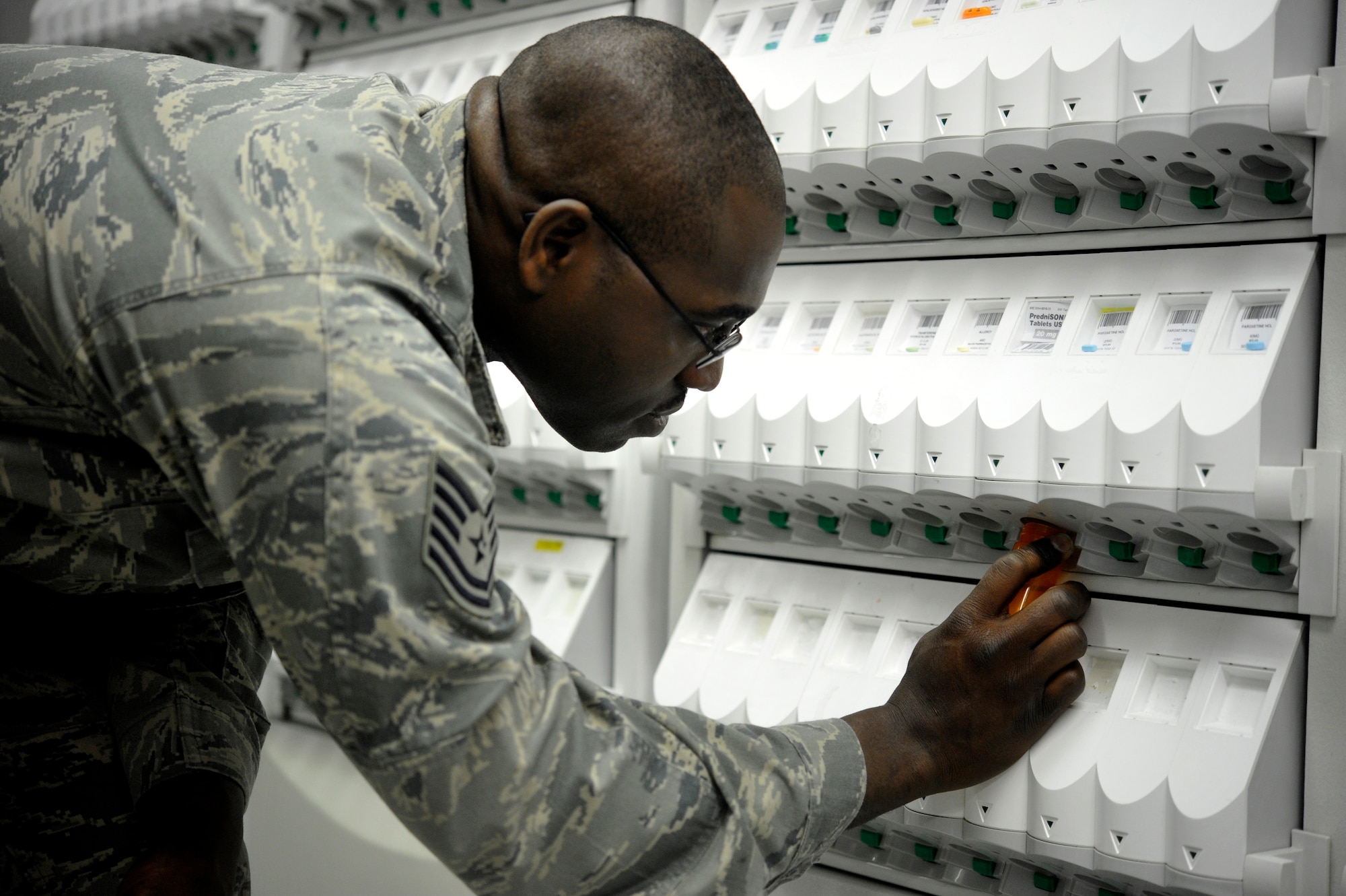 Tech Sgt. Elroy Plummer, 86th Medical Group pharmacy technician, uses a pill dispensing machine to collect medication, May 31, 2013, Ramstein Air Base, Germany. The 86th MDG pharmacy maintains readiness by providing the KMC with daily pharmaceutical needs and customer service. (U.S. Air Force photo/Senior Airman Aaron-Forrest Wainwright)